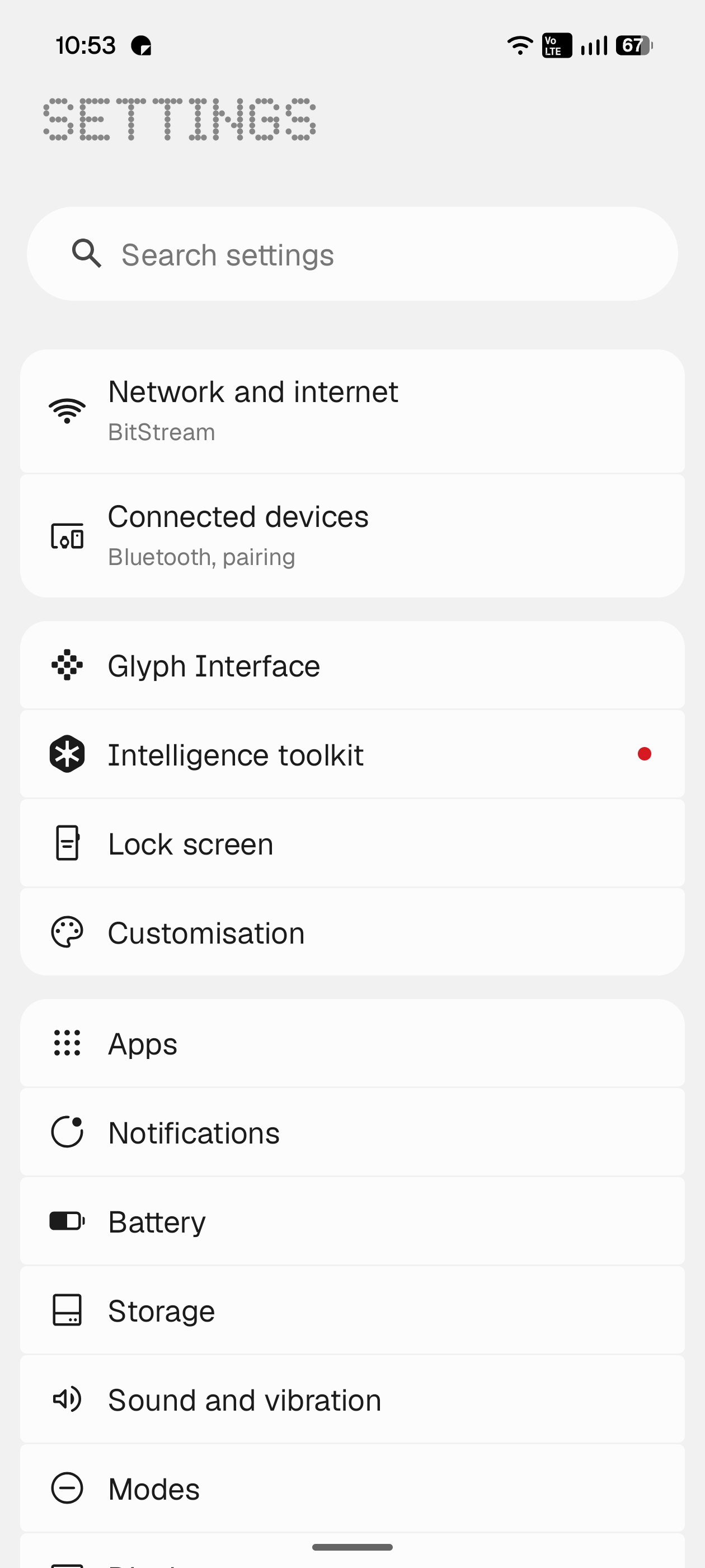 The redesigned Settings app: a dot-matrix SETTINGS header, a search field, then grouped white cards for Network and internet, Connected devices, Glyph Interface, Intelligence toolkit, Lock screen and Customisation.
