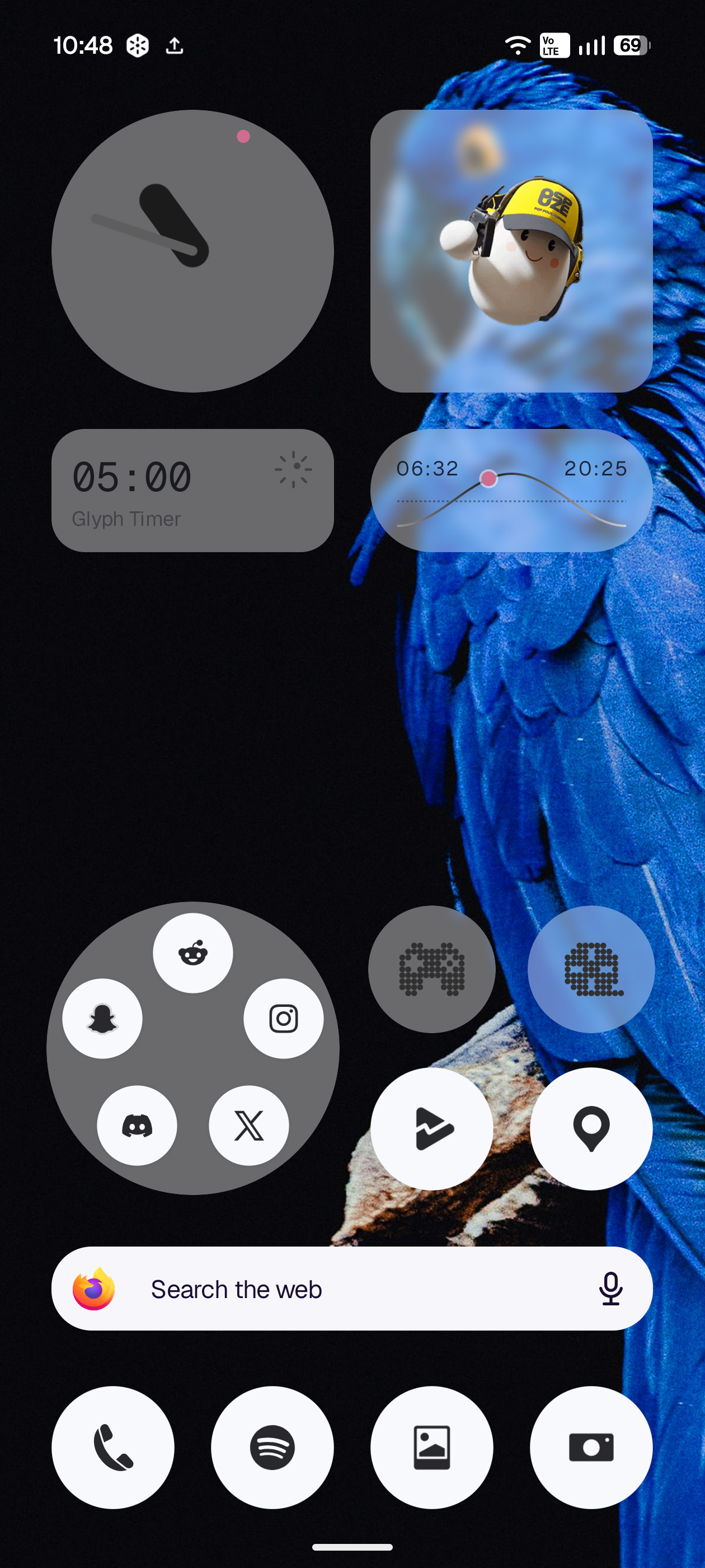 The same homescreen in Lucent style: the widgets and folders are translucent, so the black background and the macaw show through them.